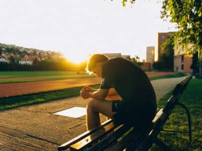 athlete sitting on bench near track and field